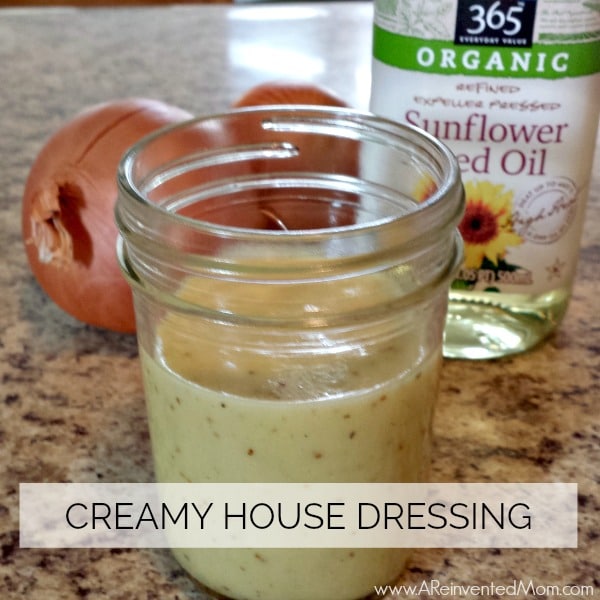 Jar of homemade Creamy House Dressing with a bottle of sunflower seed oil & 2 onions Feature | A Reinvented Mom