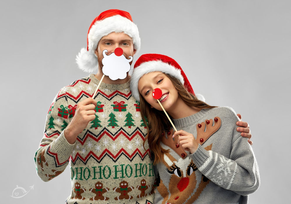 Young couple wearing ugly Christmas sweaters & Santa hats | A Reinvented Mom #funchristmaspartyideas