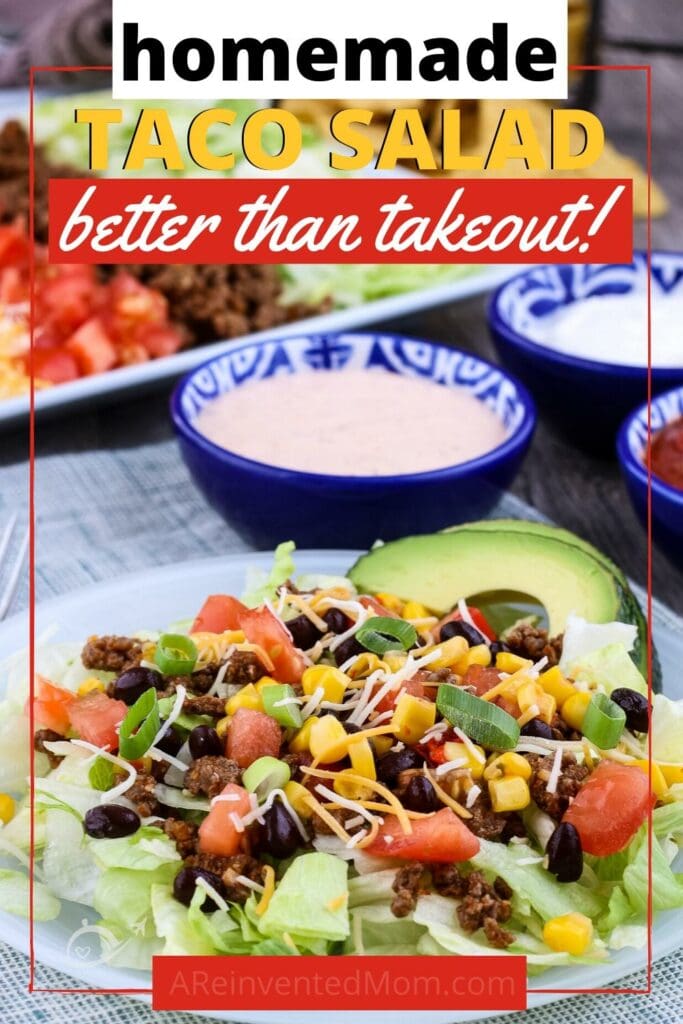 Taco salad with lettuce, ground beef, black beans, corn & cheese on a white plate with Homemade Taco Salad Better than Takeout Graphic | A Reinvented Mom