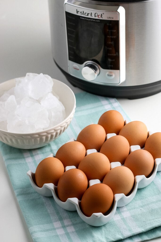Tray of eggs, bowl of ice & instant pot - ingredients to make Instant Pot Hard Boiled Eggs | A Reinvented Mom