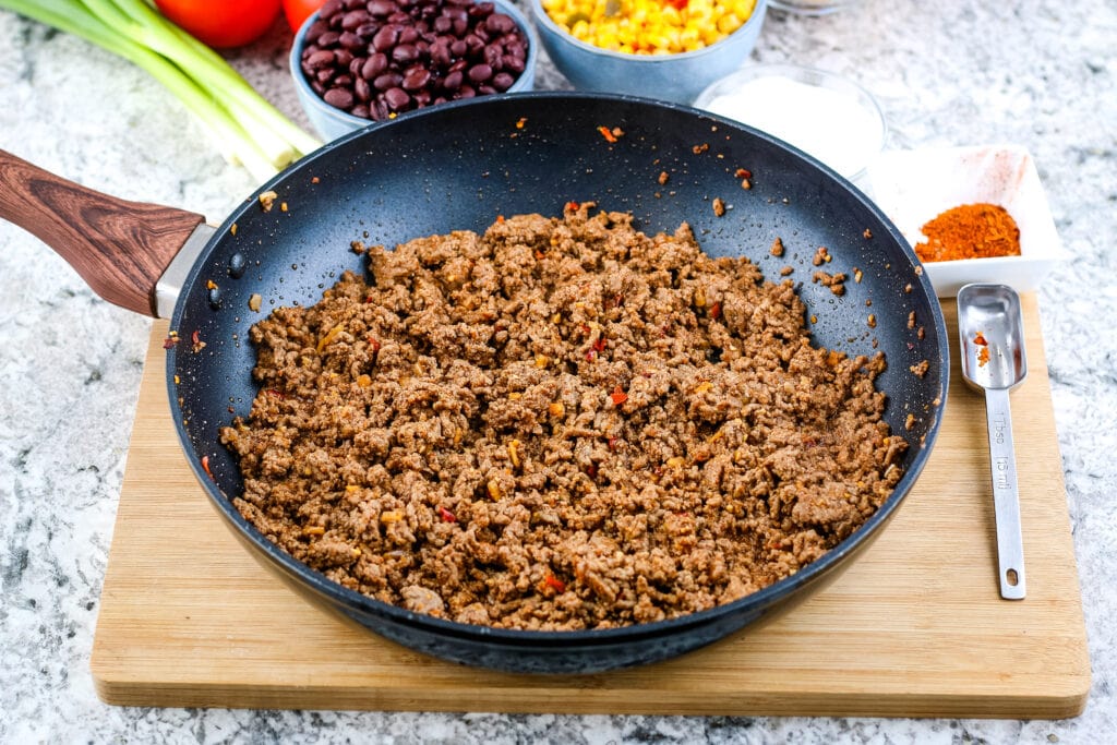 Skillet with seasoned, cooked ground beef taco meat | A Reinvented Mom