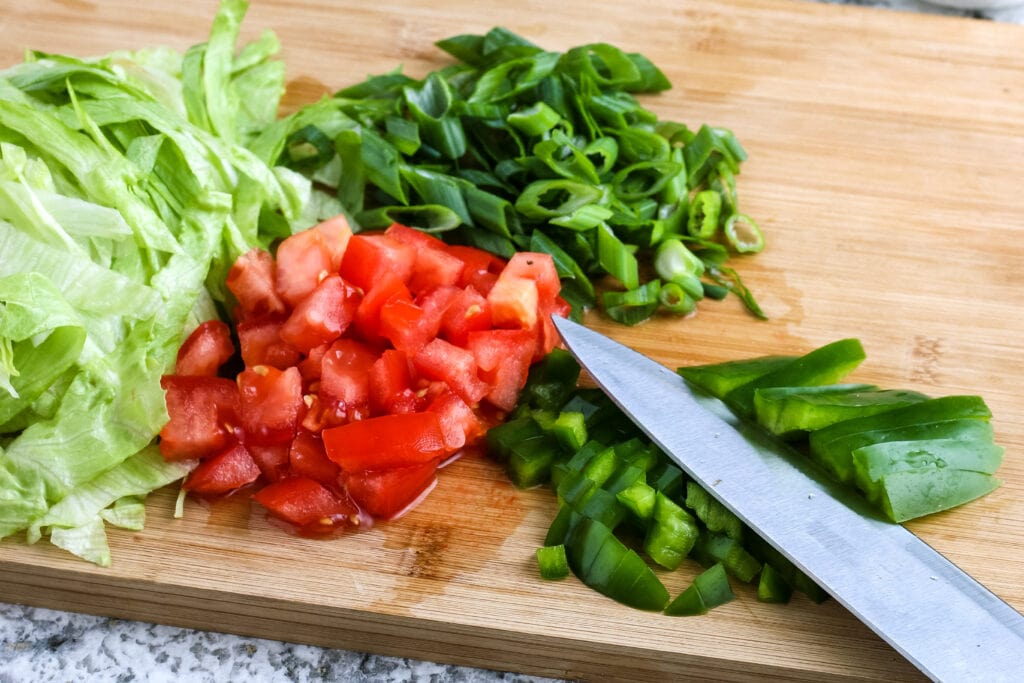 Chopped tomato, lettuce, onion & green pepper on a cutting board | A Reinvented Mom