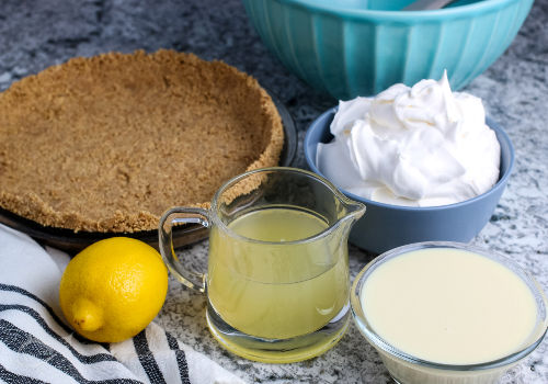 Graham cracker crust, lemon & juice, whipped cream & condensed milk ingredients for Lemonade Pie | A Reinvented Mom