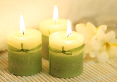 Spa candles with white flowers in the background.