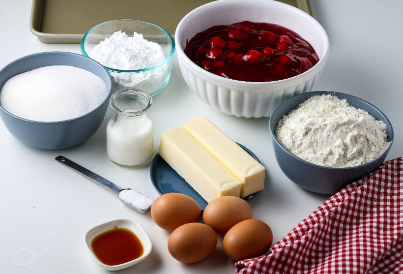 Ingredients - bowls of sugar, flour, confectioners sugar, cherry pie filling & vanilla, milk, 2 sticks of butter, 4 eggs & salt | A Reinvented Mom