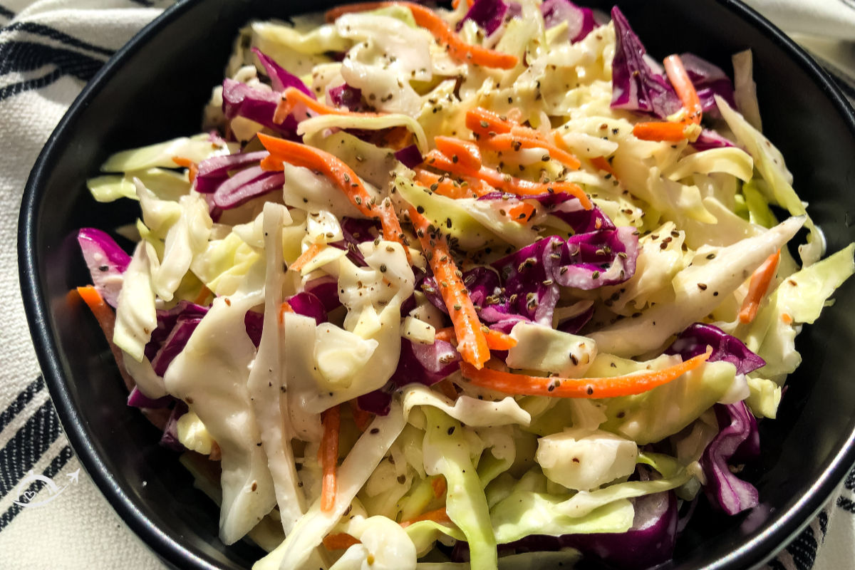 Simple southern coleslaw topped with black pepper after it has been mixed.