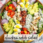 Chicken Cobb salad in a wooden bowl with text overlay.