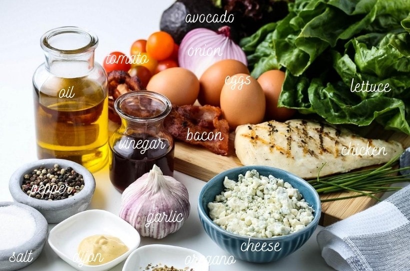 All ingredients for Chicken Cobb Salad sitting on white counter and labeled