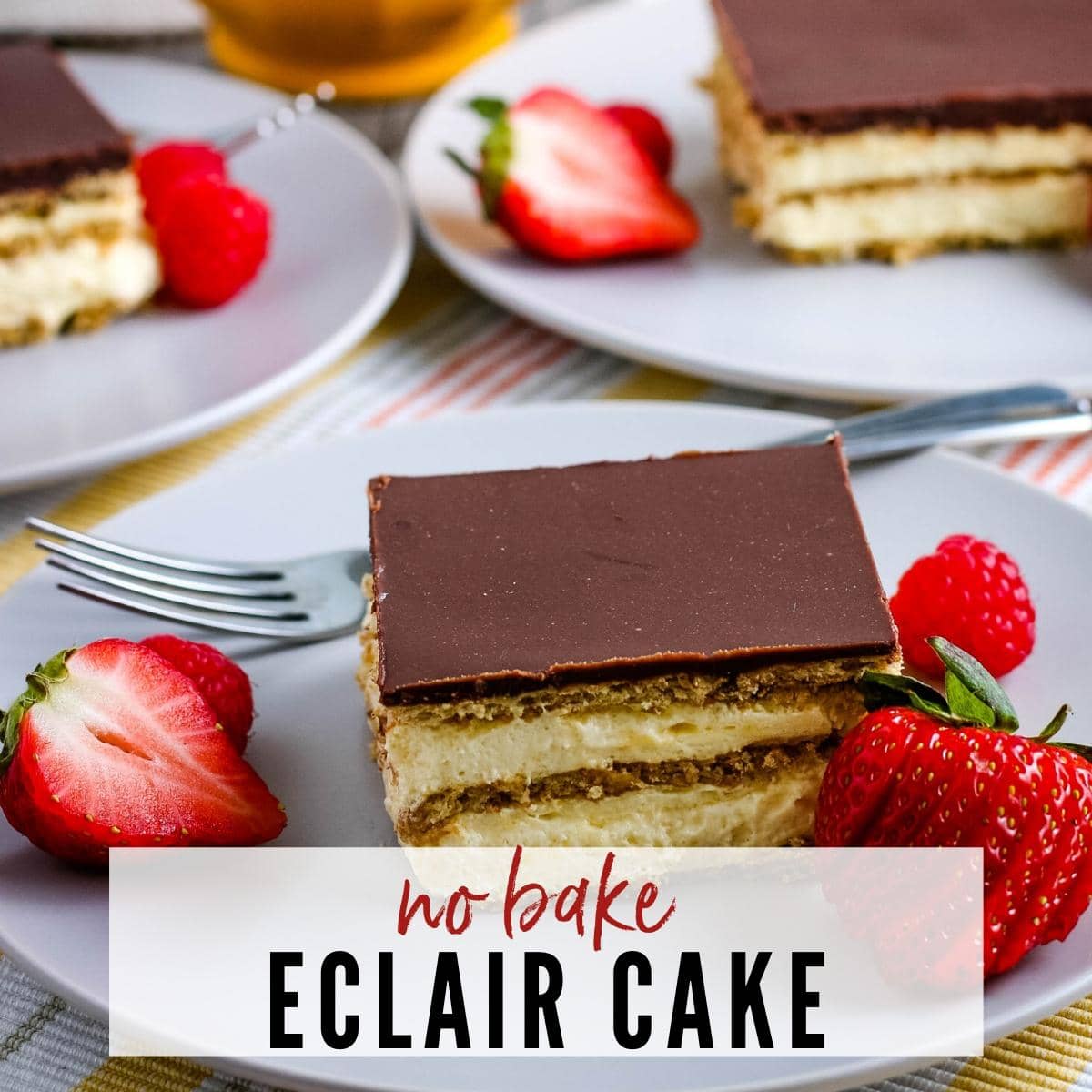 close up of a slice of eclair cake next to strawberries on a white plate