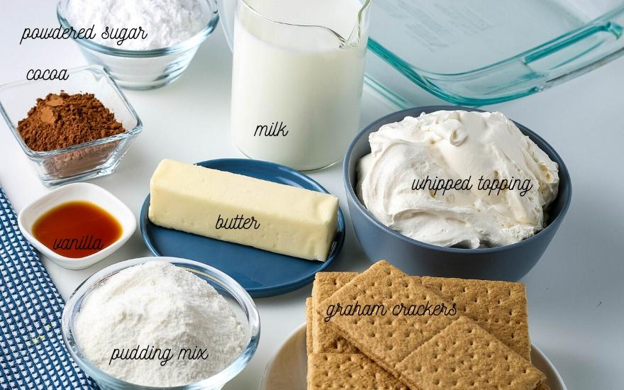 All of the ingredients needed for  eclair cake labeled on a white countertop.