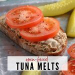 closeup of open faced tuna melt after cooking next to pickle spears