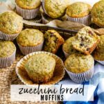 close up of zucchini muffins after baking some whole and one broken in half with text overlay