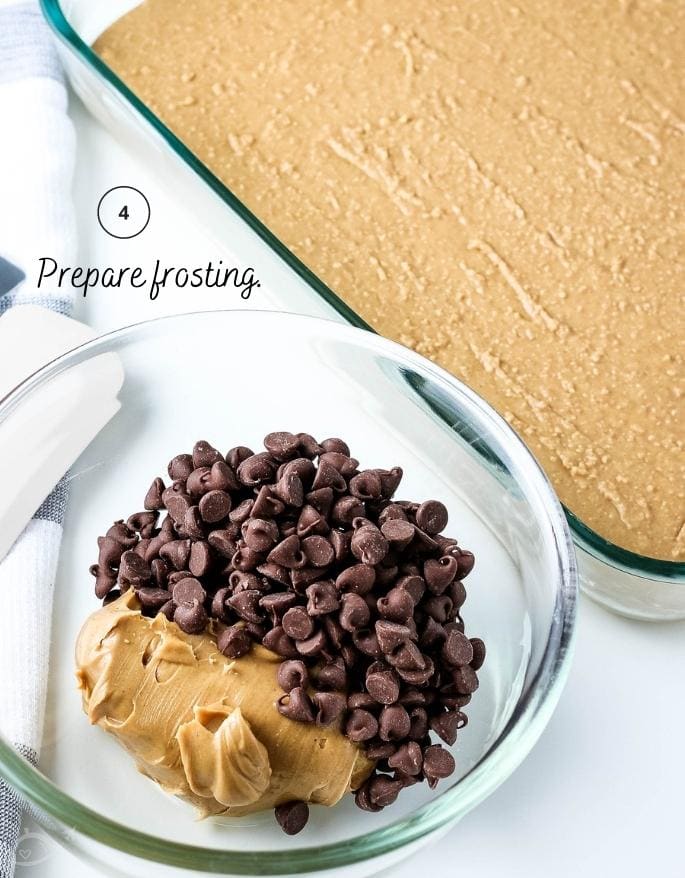 Peanut butter and chocolate chips in a glass bowl next to baking dish with graham cracker layer.