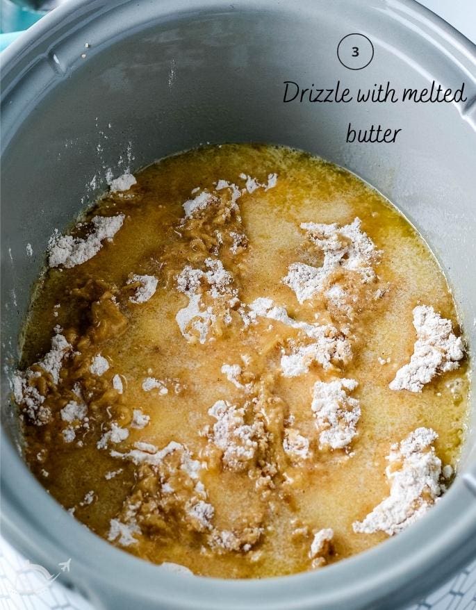 apple dump cake in a crockpot before baking after butter has been drizzled