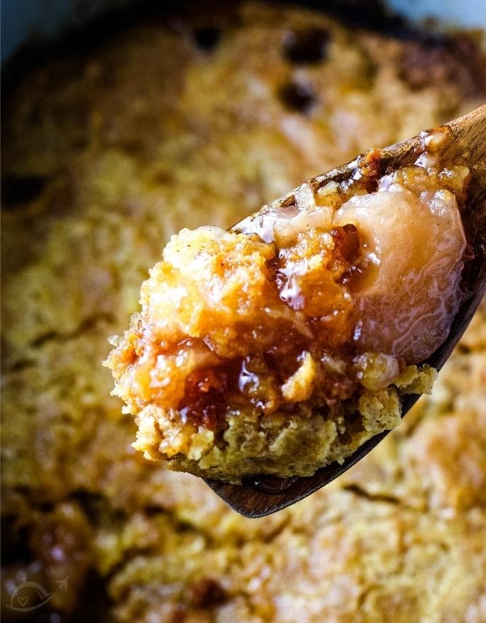 apple dump cake on a spoon with the rest in the background