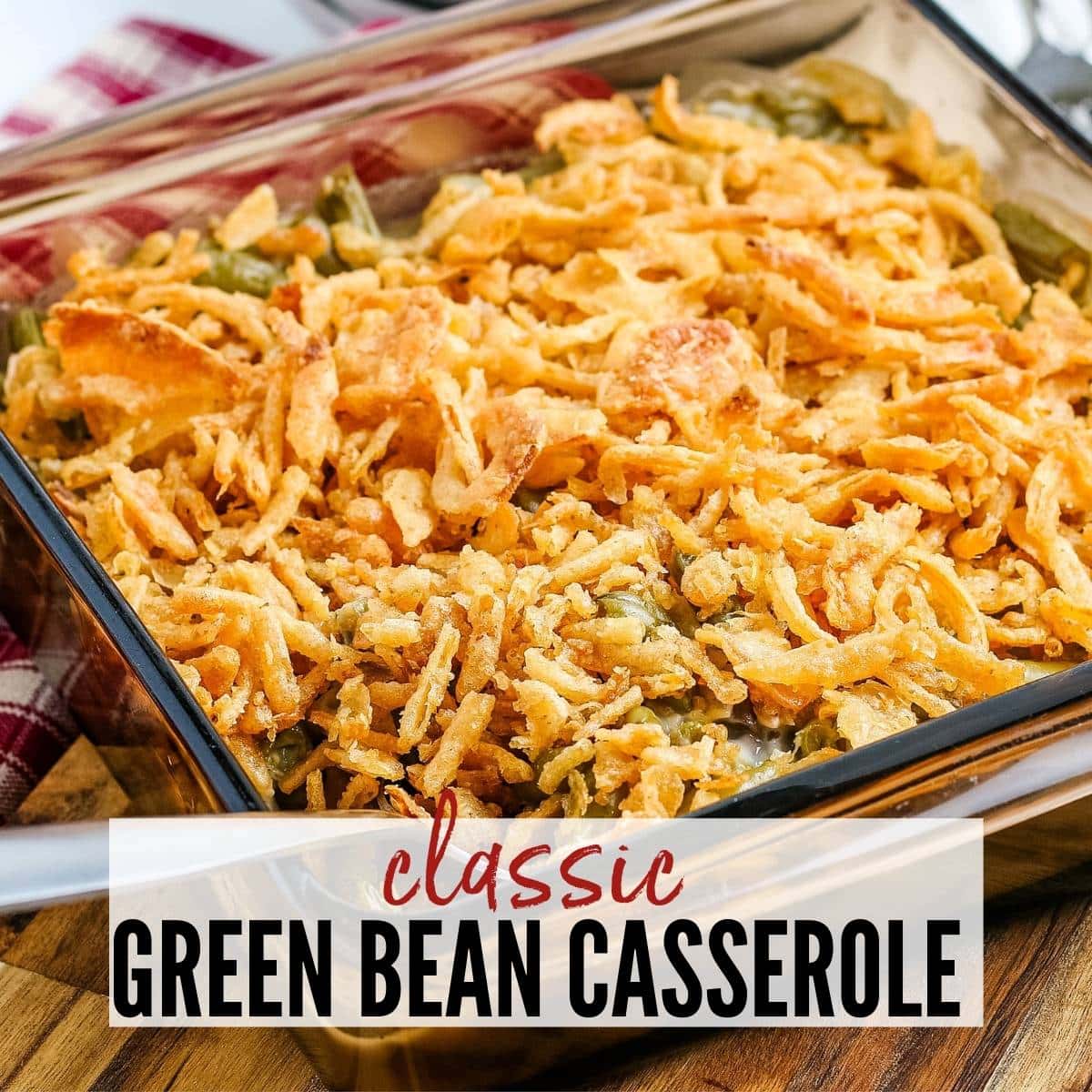 Close up view of green bean casserole topped with fried onions in a glass dish with text overlay.