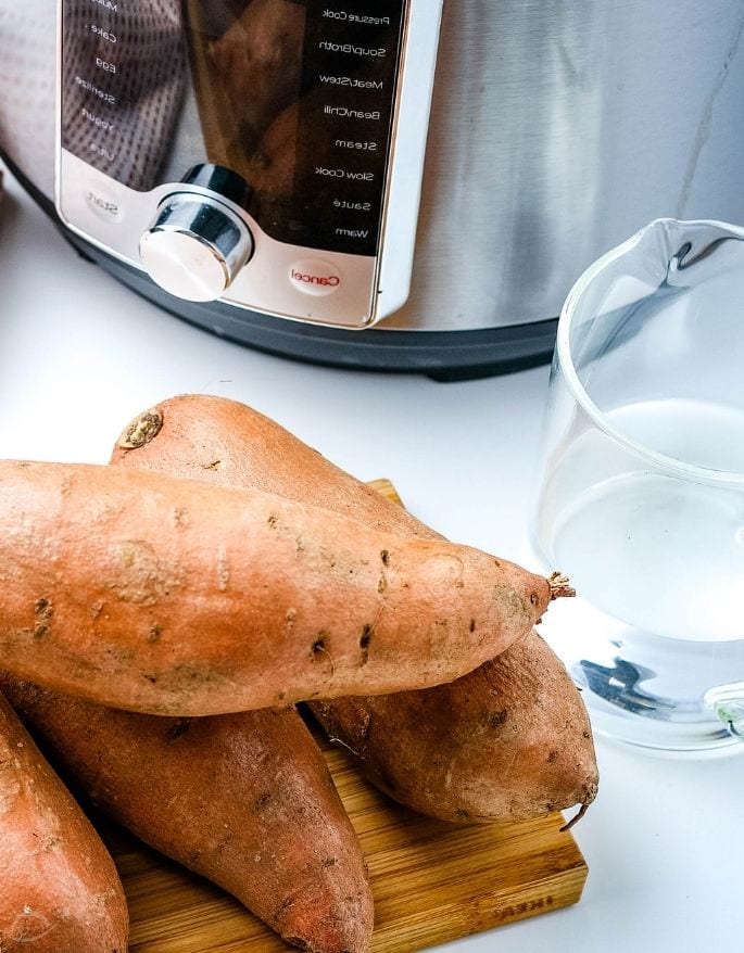 sweet potatoes and water sitting next to an Instant Pot pressure cooker