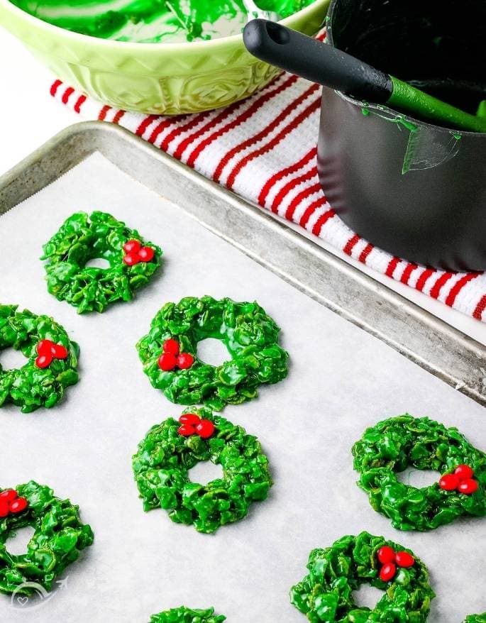 christmas cornflake wreath cookies with red candies on parchment paper