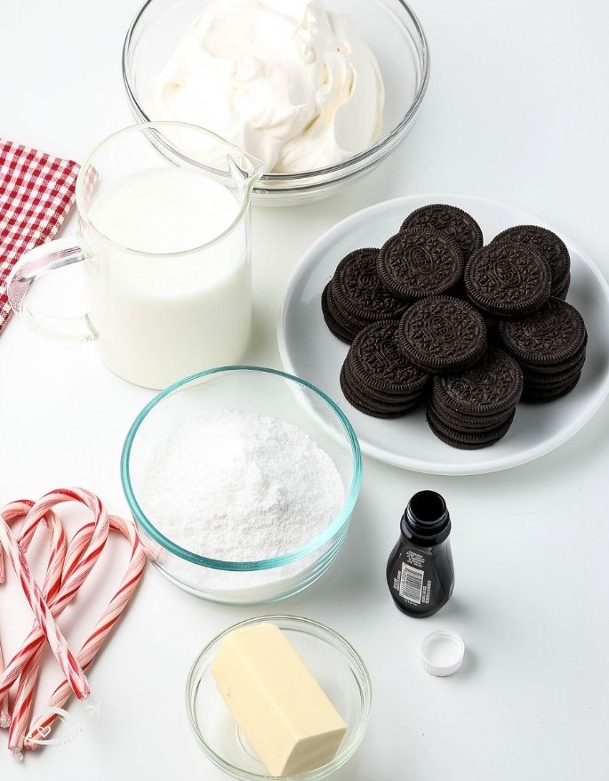 Ingredients for candy cane pie in glass bowls and oreos on a white plate