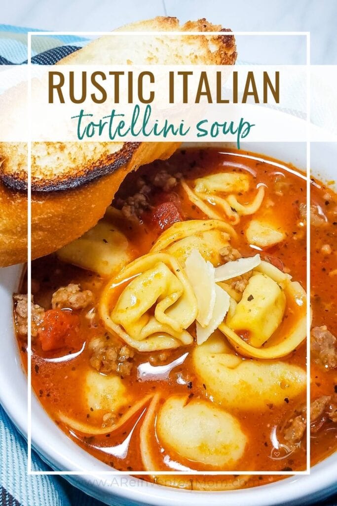 White bowl filled with rustic Tortellini Soup on a striped towel with a slice of bread and graphic overlay.