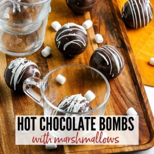 close up of hot chocolate bombs on a tray and in a glass with text overlay