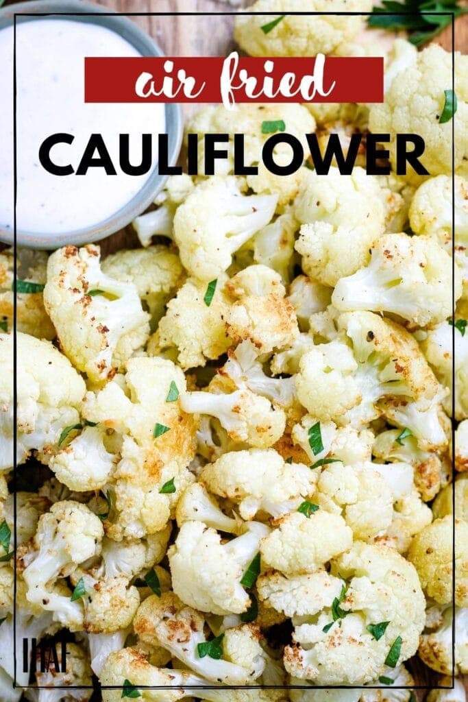 close up of cauliflower that has been air fried, next to sauce, topped with green garnish