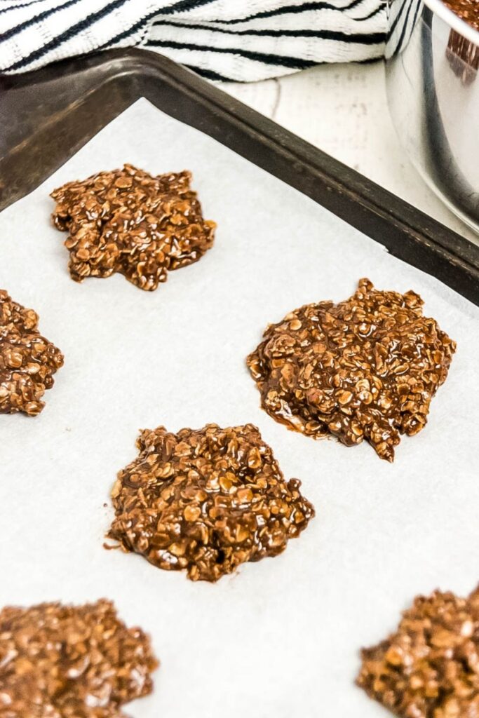 No Bake Preacher cookies on parchment paper with mixing bowl behind it