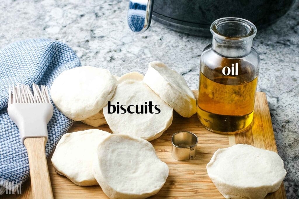 Ingredients for biscuit doughnuts on a wooden cutting board