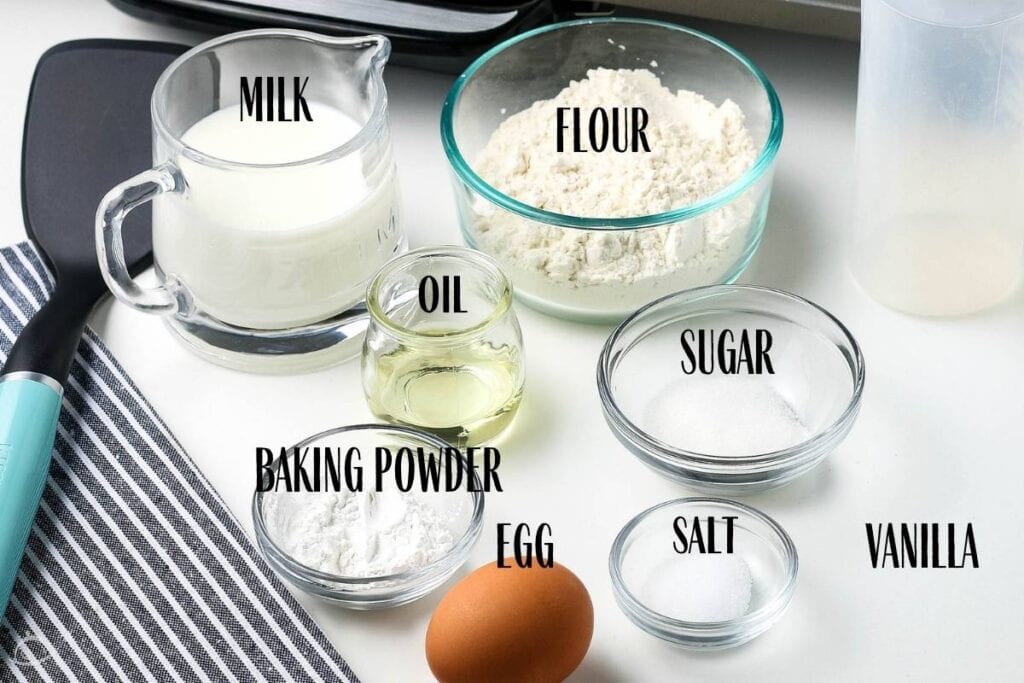 ingredients labeled and in glass containers for mini pancake cereal next to griddle