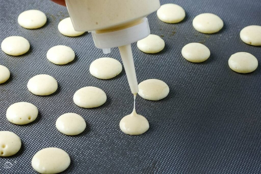 squeezing pancake batter out onto griddle from the plastic squeeze bottle