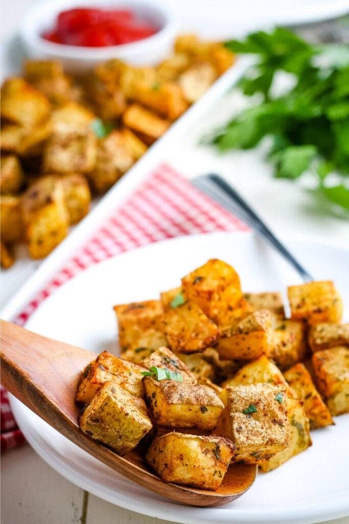 air fried diced potatoes on a spoon over a white plate