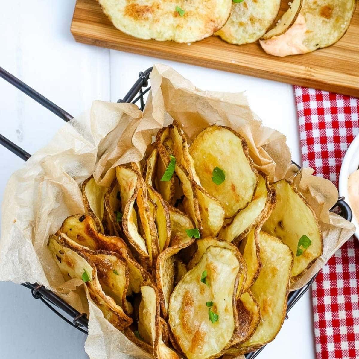 top view of air fried potato chips in a basket on a white board