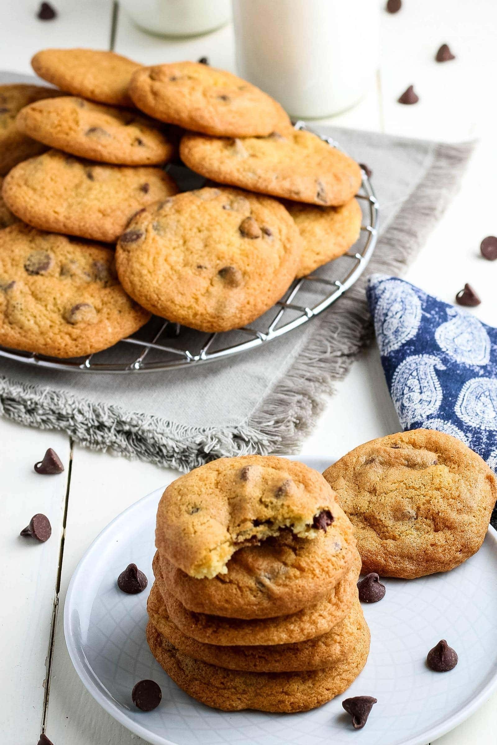 stack of air fryer chocolate chip cookies next to the rest of the batch on a wire rack