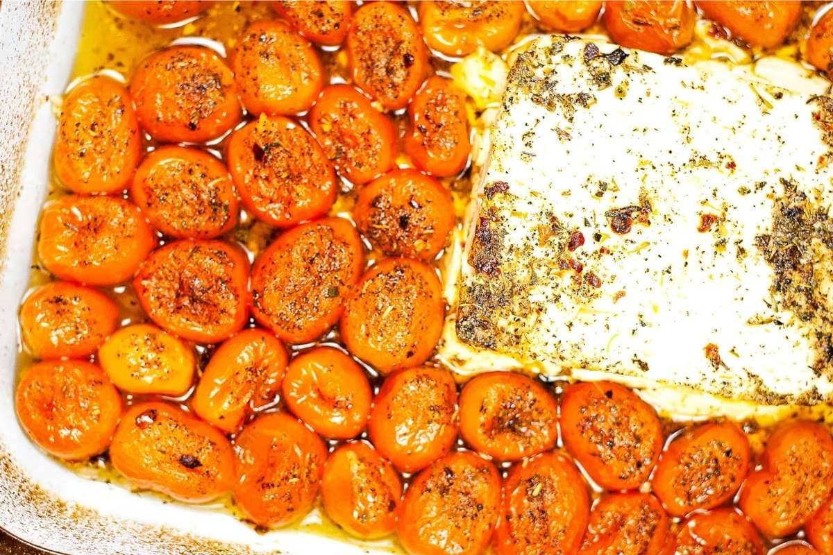 Close up view of cooked feta tomato mixture in baking dish. 