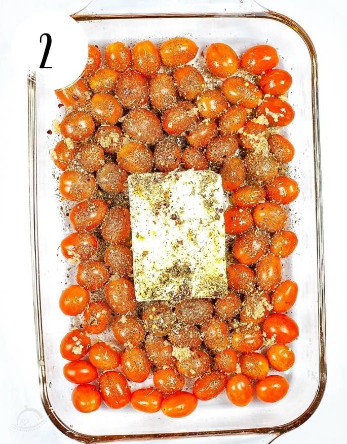 cheery tomatoes and feta block in a glass baking dish