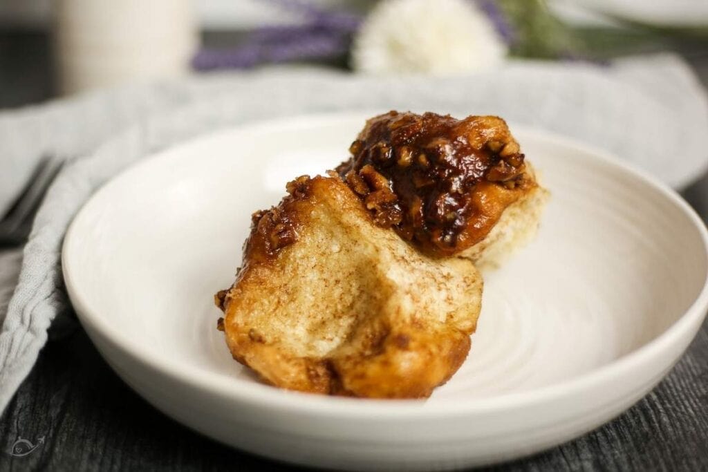 a piece of pecan monkey bread in a white bowl after baking