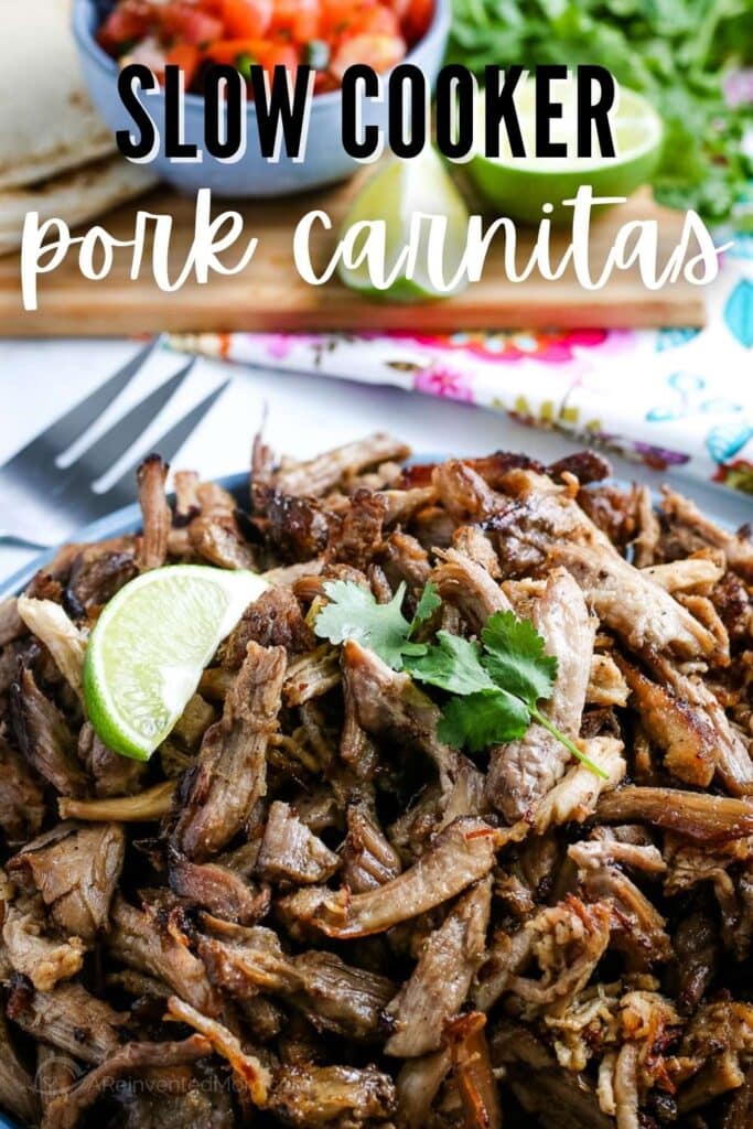 Pork carnitas after being cooked in the crockpot and topped with a lime wedge with text overlay.