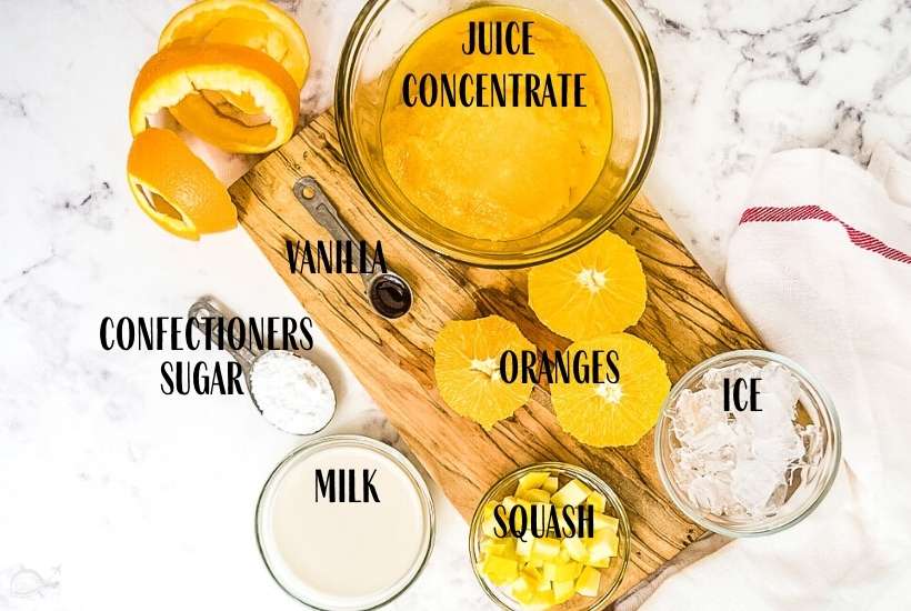 labeled ingredients to make copycat orange Julius drink on marble background