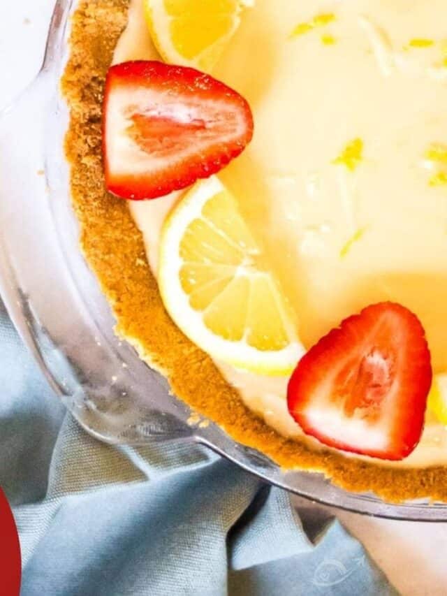 top view of lemon icebox pie after chilling with lemon wedges and strawberry halves for garnish with text overlay