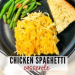 slice of chicken spaghetti with green beans and garlic bread on a black plate with graphic overlay