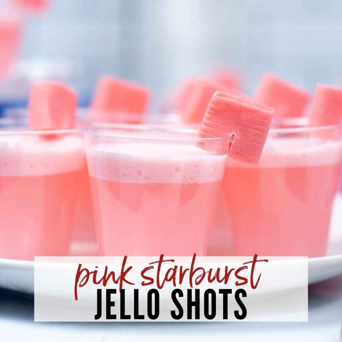 pink jello shots with starburst candy on the side for garnish with text overlay