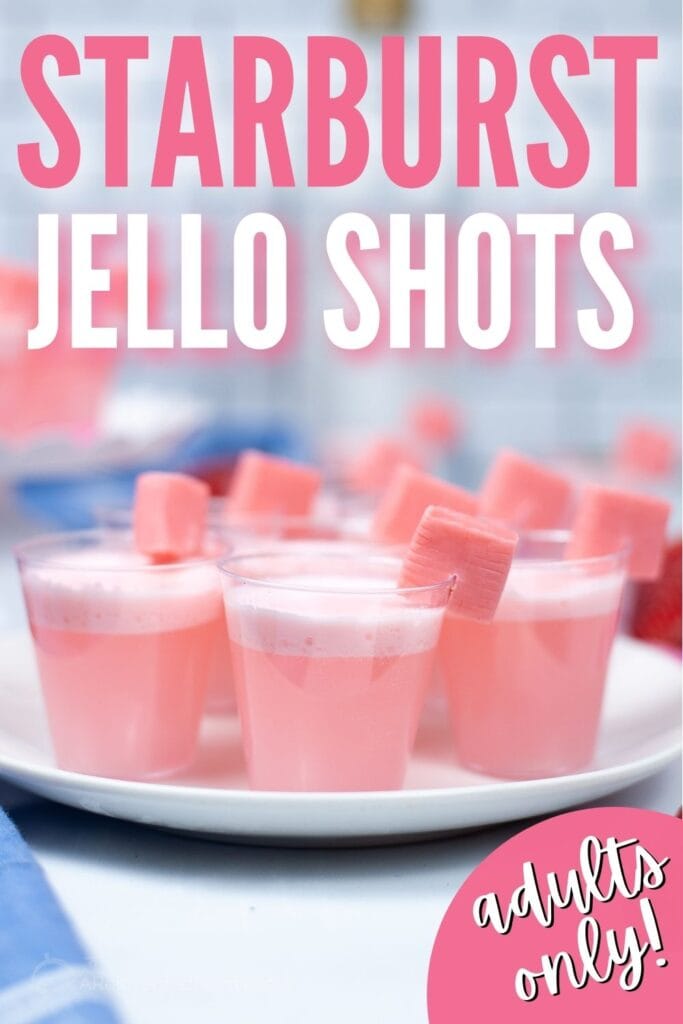 starburst jello shots on a white tray with pink starburst candies on the side with text overlay