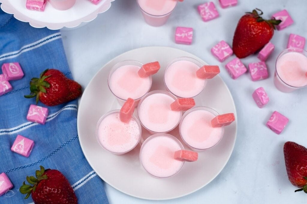 top shop of pink jello shots with starburst candy on the side of the cup