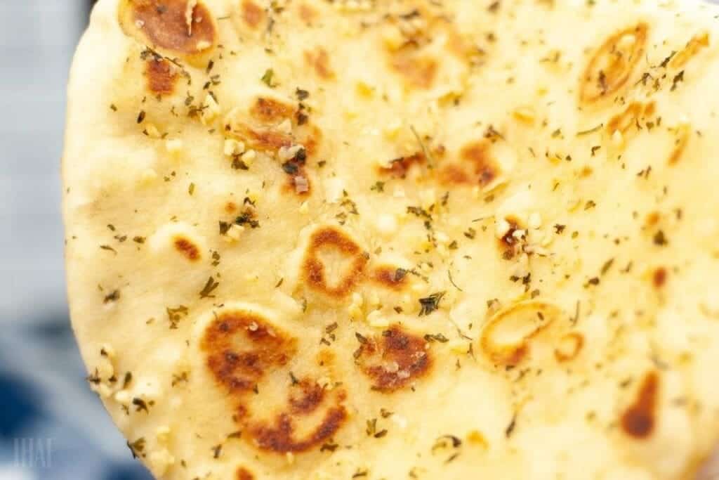 close up of air fryer naan bread with brushed garlic butter