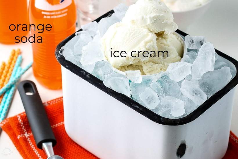 ice cream in a bucket with ice next to orange soda