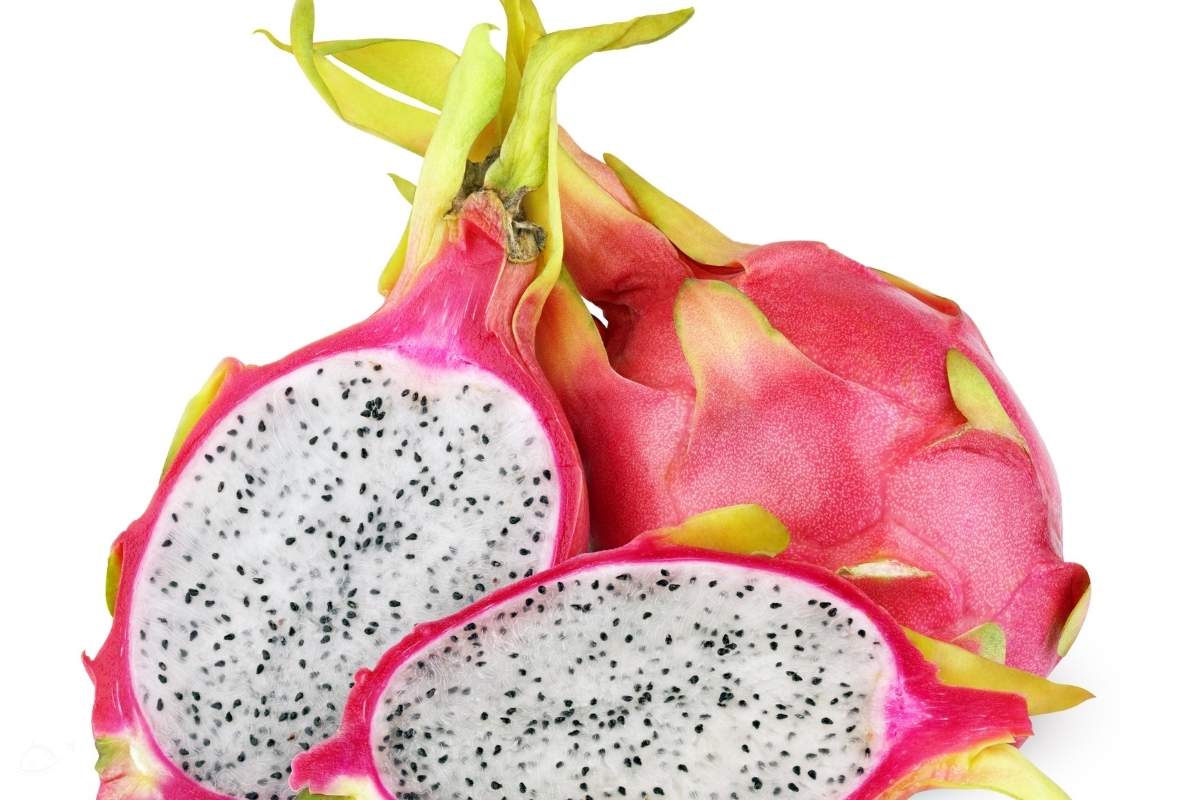 dragon fruit cut in half in front of a whole pitaya