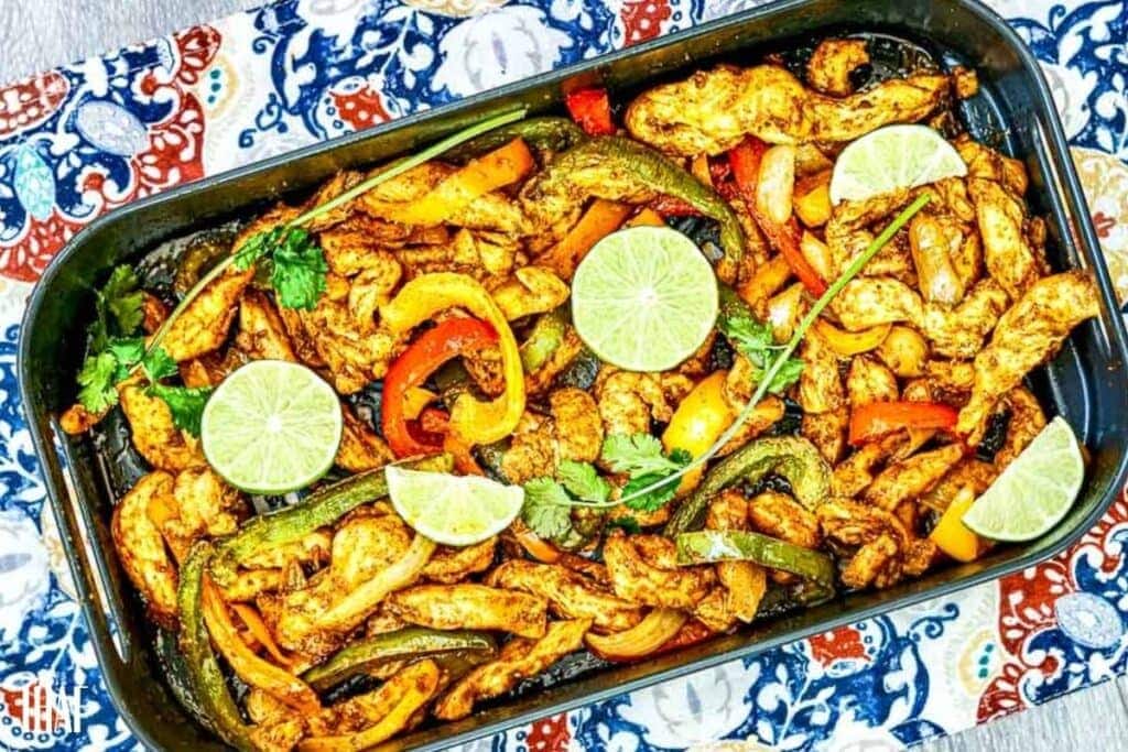 top view of chicken fajitas made in a air fryer, transferred to serving dish