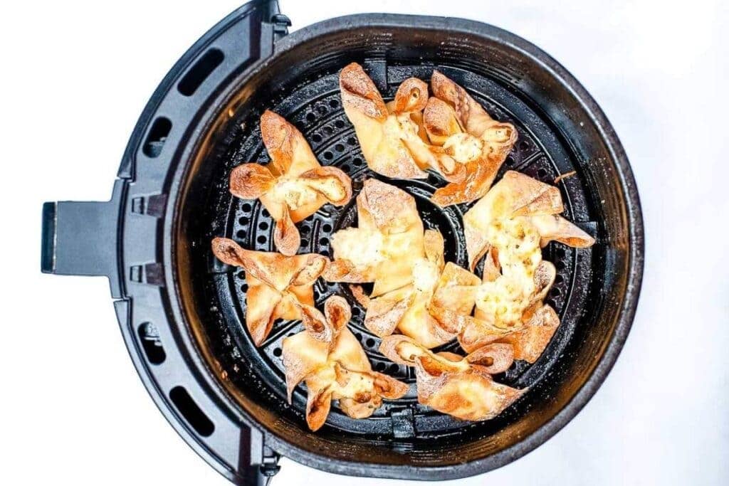 top shot of crab rangoons in the air fryer basket after cooking