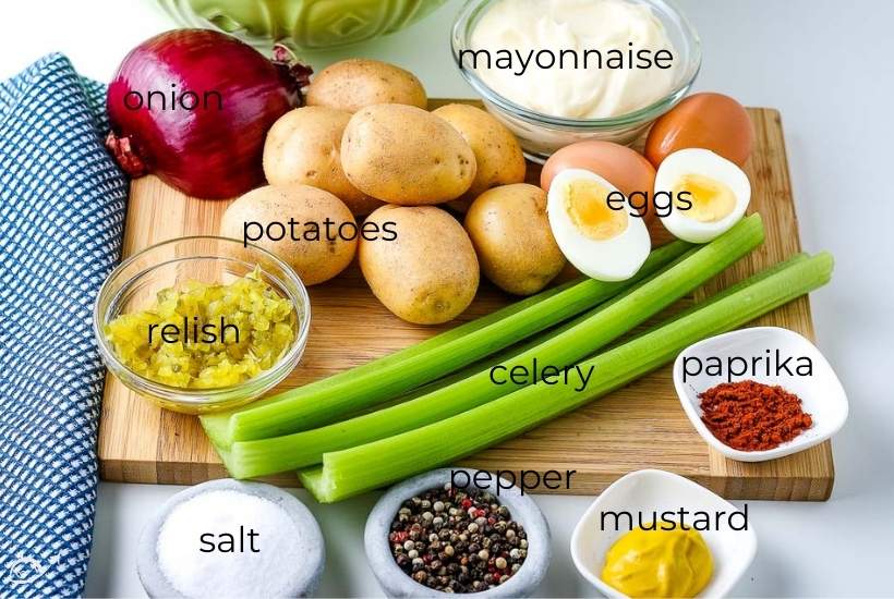 labeled ingredients to make country style potato salad on a wooden cutting board