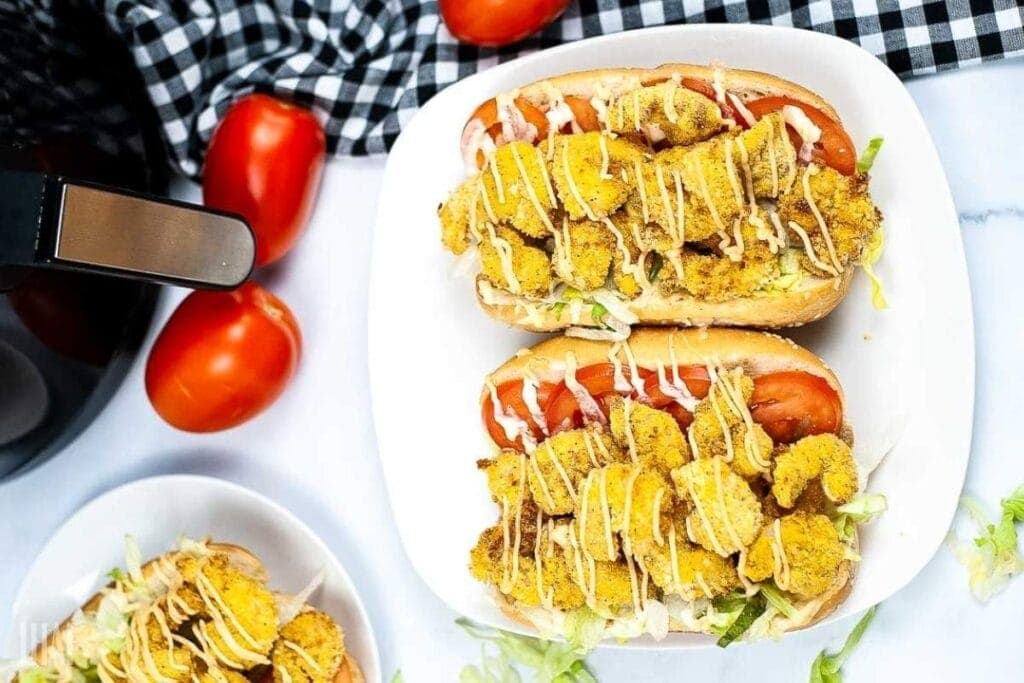 top shot of two shrimp po boys drizzle with cajun sauce